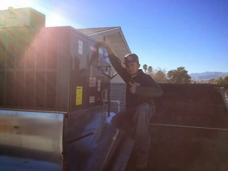 HVAC technician performing Air Duct Cleaning on a rooftop unit in Dent